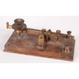 A gilt metal morse code key on a wooden base, height 9.5cm, width 28cm, depth 12cm.