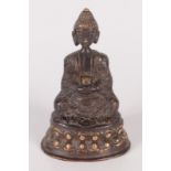 A South East Asian bronze figure of a seated man, 19th century, with a gilt headdress and base,