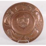 An Arts and Crafts circular copper plaque,