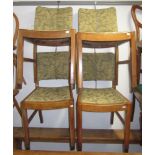 A set of four Arts and Crafts oak dining chairs, with drop in seats and leaf decorated upholstery,