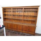 A large Edwardian oak open bookcase, the moulded cornice above four shelves,
