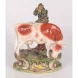 A Staffordshire pottery figure of a cow before a tree, early 19th century,