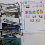 A quantity of postcards and a juvenile stamp album.