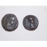 Two Greek bronze coins, one with radiant crown male, reverse a veiled woman.