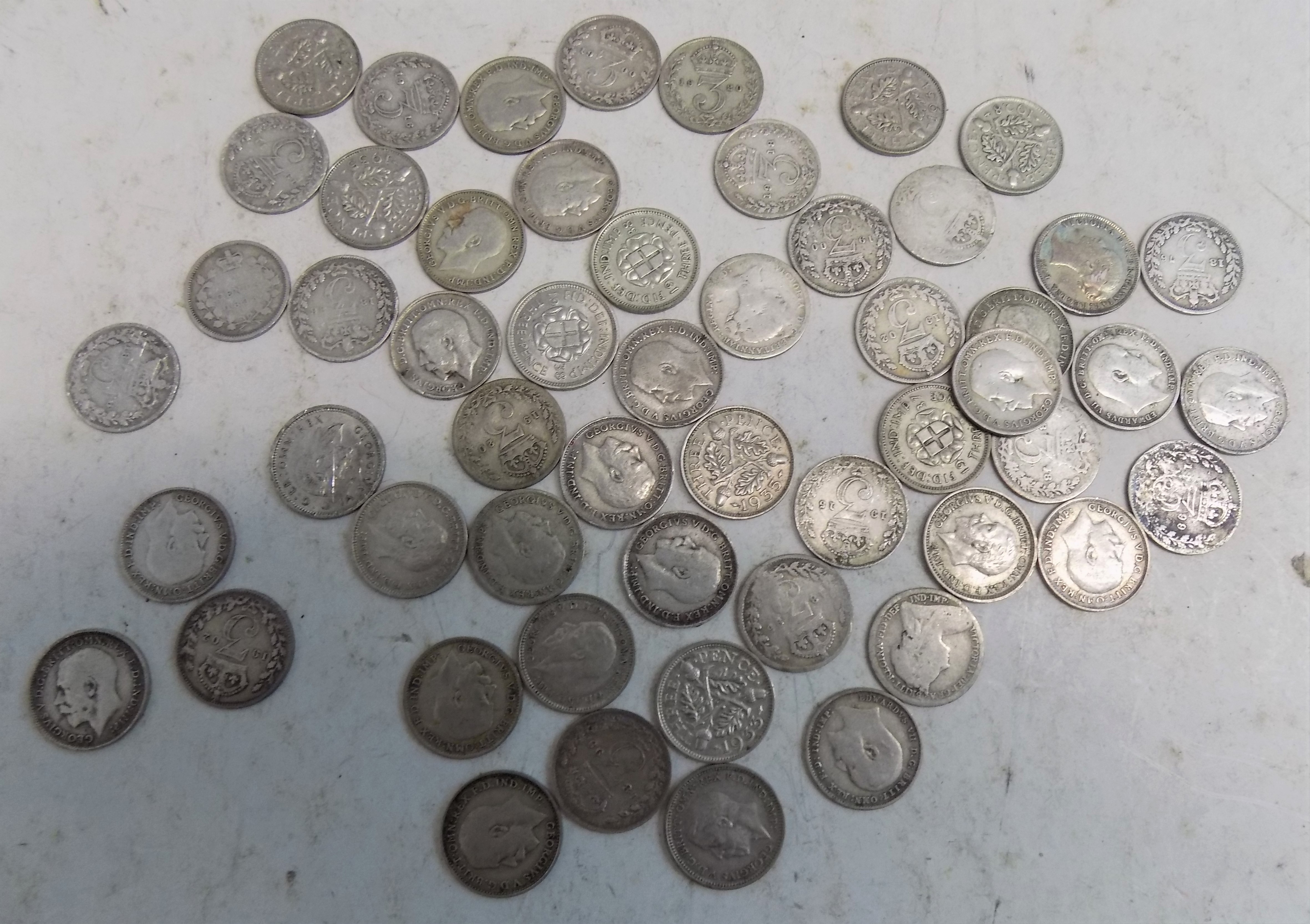 Approximately fifty silver 3d pieces.