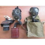 A collection of gas masks including two child's masks, three adult masks dated 1938, 1941 and 1939,