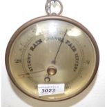 An aneroid barometer in brass case.