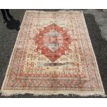A Heriz design carpet, the ivory field with a large madder medallion, with hooked guls,