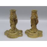 A pair of continental gilt metal candlesticks, the body decorated with leaves and floral swags,