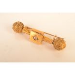 A Revivalist Victorian gold bar brooch, at the centre a diamond, at each end a steer,