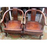 A pair of Chinese huali wood tub armchairs, each with a central vertical carved splat,