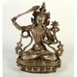 A Tibetan silvered bronze figure of a seated deity, height 21cm.