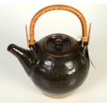 A Leach globular tenmoku glazed teapot with cane handle.