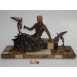 An Art Deco marble and onyx figure of a spelter seated lady and a bird, height 26cm, length 67cm,