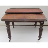 A Victorian mahogany extending dining table, the moulded top on turned and fluted tapering supports,