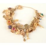 A 9ct gold curb-link charm bracelet mounted with numerous gold charms, 71.8g.