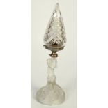 A frosted glass table lamp, in the form of a seated semi naked lady, with a cut glass shade,