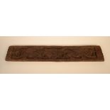 An early carved oak panel, decorated with stylised dragons, height 12.7cm, width 76.5cm.