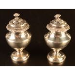A pair of William IV vase shape condiments each with pierced lid and fruit finial,