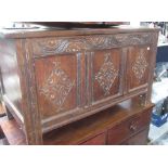 A oak coffer, 17th century, with a plain triple panelled top above a carved front on stile legs,