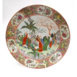 A Chinese Canton dish, 19th century, decorated with figures beneath trees, diameter 34.5cm.