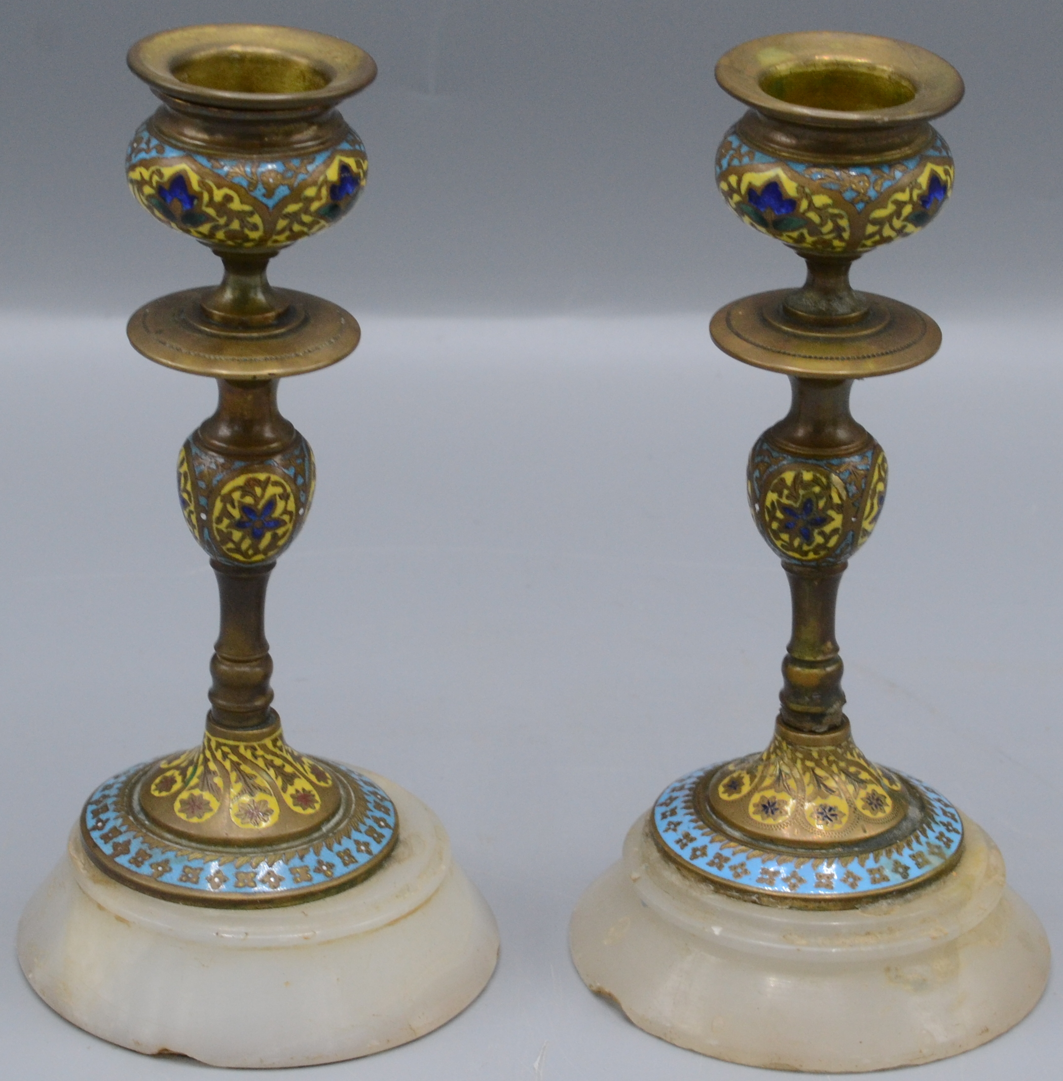 A pair of continental champleve enamel candlesticks, circa 1900, height 14.5cm, diameter 7.3cm.