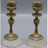 A pair of continental champleve enamel candlesticks, circa 1900, height 14.5cm, diameter 7.3cm.