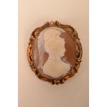 A gold mounted cameo brooch carved with the head of a helmeted warrior.