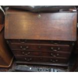 A George III oak bureau, the fall front opening to reveal a fitted interior above four long drawers,
