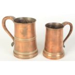 Two copper tankards, early 19th century, each with wooden bases, heights 15.5cm and 13.5cm.