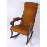 A Victorian mahogany rocking chair, with yellow upholstered padded back, arms and seat,