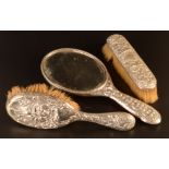 Two silver mounted brushes and a silver mounted hand mirror.