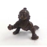 A South East Asian miniature bronze figure of a semi naked boy, height 4cm, length 4cm.