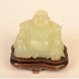 A Chinese jadite on a wooden stand, total height 10cm, width 10cm.