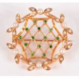 A 15ct gold Belle Epoque brooch, set with a trellis of demantoid garnets within a wreath of pearls,