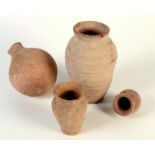 Four terracotta jars, possibly Roman, one bearing the remains of an old paper label,