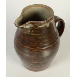 A Leach pottery jug, with a ribbed body, part tenmoku glaze, height 20cm.