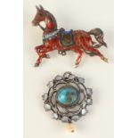 A silver enamel brooch in the form of an eastern war horse,