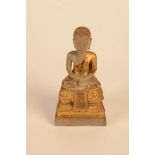 A Chinese marble and gilt decorated Buddha, faint indistinct inscription to front of plain plinth,