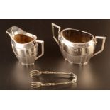 An Edwardian fluted sugar bowl and matching milk jug together with a pair of ornate silver sugar