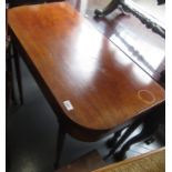 An inlaid mahogany tea table, early 19th century, with a fold over top on turned tapering legs,