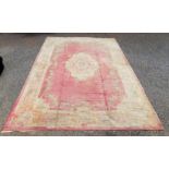 A Donegal carpet of Aubusson design, the pink ground with a central floral medallion and corners,