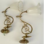 A pair of brass wall lights, early 20th century, with milk glass shades, length 47cm, height 30cm.