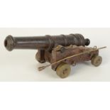 An iron model cannon, 19th century, on later carriage, length 27cm.