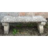 A composition garden bench with scroll decorated supports, height 47cm, width 128cm, depth 39cm.
