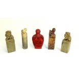 Four Chinese soapstone seals, all surmounted with dog of fo and a cinnabar lacquer scent bottle.