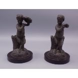 A pair of Victorian metal spill holders, in the form of fauns, each on a circular black marble base,