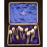 A set of ten silver tea spoons with pierced handles together with a pair of matching sugar tongs by