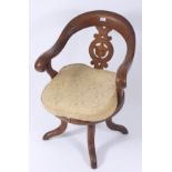 A Victorian revolving office chair, with a pierced splat above a solid seat on four downswept legs,