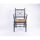 A William Morris style ebonised Sussex armchair, with a rush seat on turned legs, height 90cm,